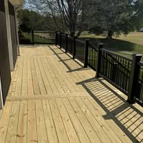 Wood deck boards running beside the house and black railing