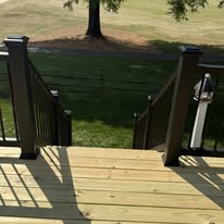 Wood deck stairs bordered by black railings