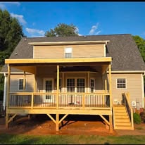 Full view of the covered deck and stairs behind the house