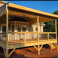 Angled view of covered deck with wood posts and railing