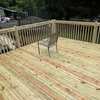 Wood pool deck with chair and perimeter railing