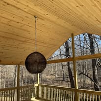 Vaulted wood ceiling above a deck with hanging light