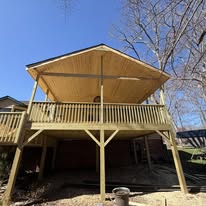 Front view of elevated deck with vaulted cover and wood railing